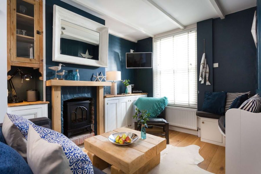 Seafront cottage in St Ives interior with blue walls, wooden coffee table and log burner.