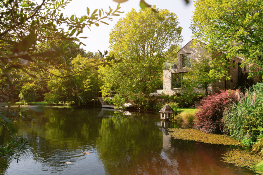 Little Cutmadoc Farm house surrounded by woodland green trees and large natural pond location in Lanhydrock National Trust and let by Cornish Gems